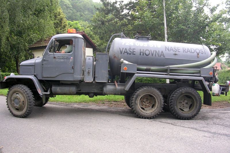 Septic tank pumper truck parked on a village street